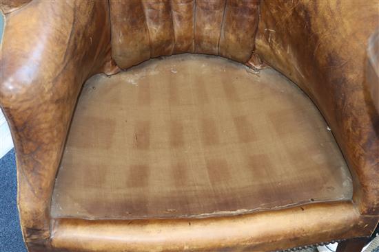 A George III mahogany hide-covered wing chair